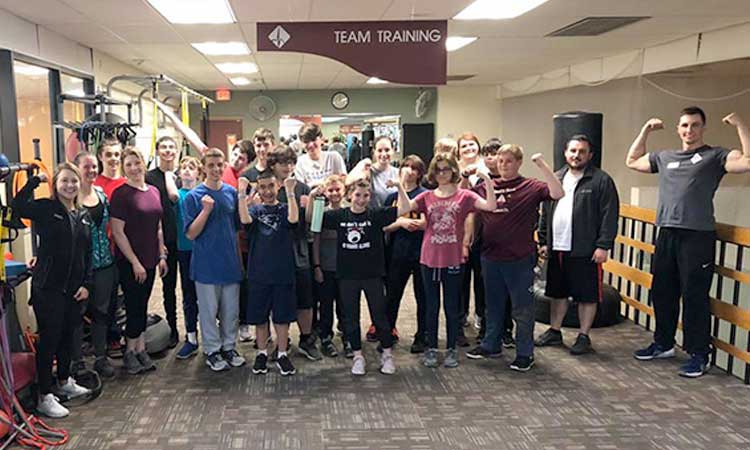 Group of students holding up their arms, showing off their muscles.