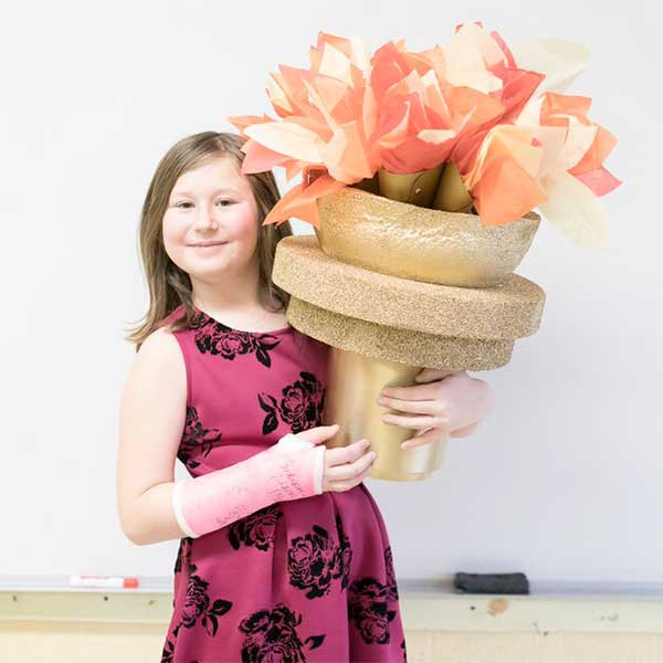 Young girl holding an. Olympic Torch made from paper.