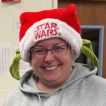 A teacher wearing a Santa hat.