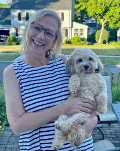 Catherine Quirk, Nurse Catherine Quirk, smiling holding her small dog in her arms.