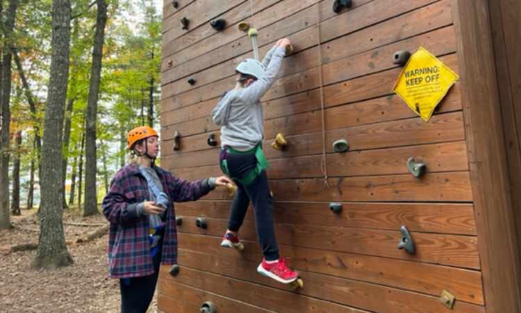 Instructor and student at outdoor climbing wall.