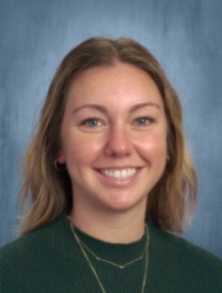 Smiling, young female teacher with long, dark blond hair.