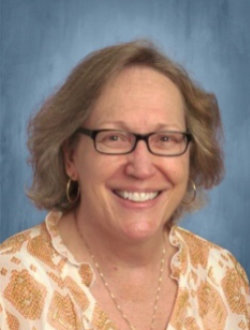 Female math teacher, smiling, with glasses.