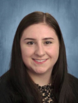 Smiling female teacher with long brown hair.