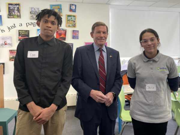 A male and female student with Senator Blumenthal in the center.